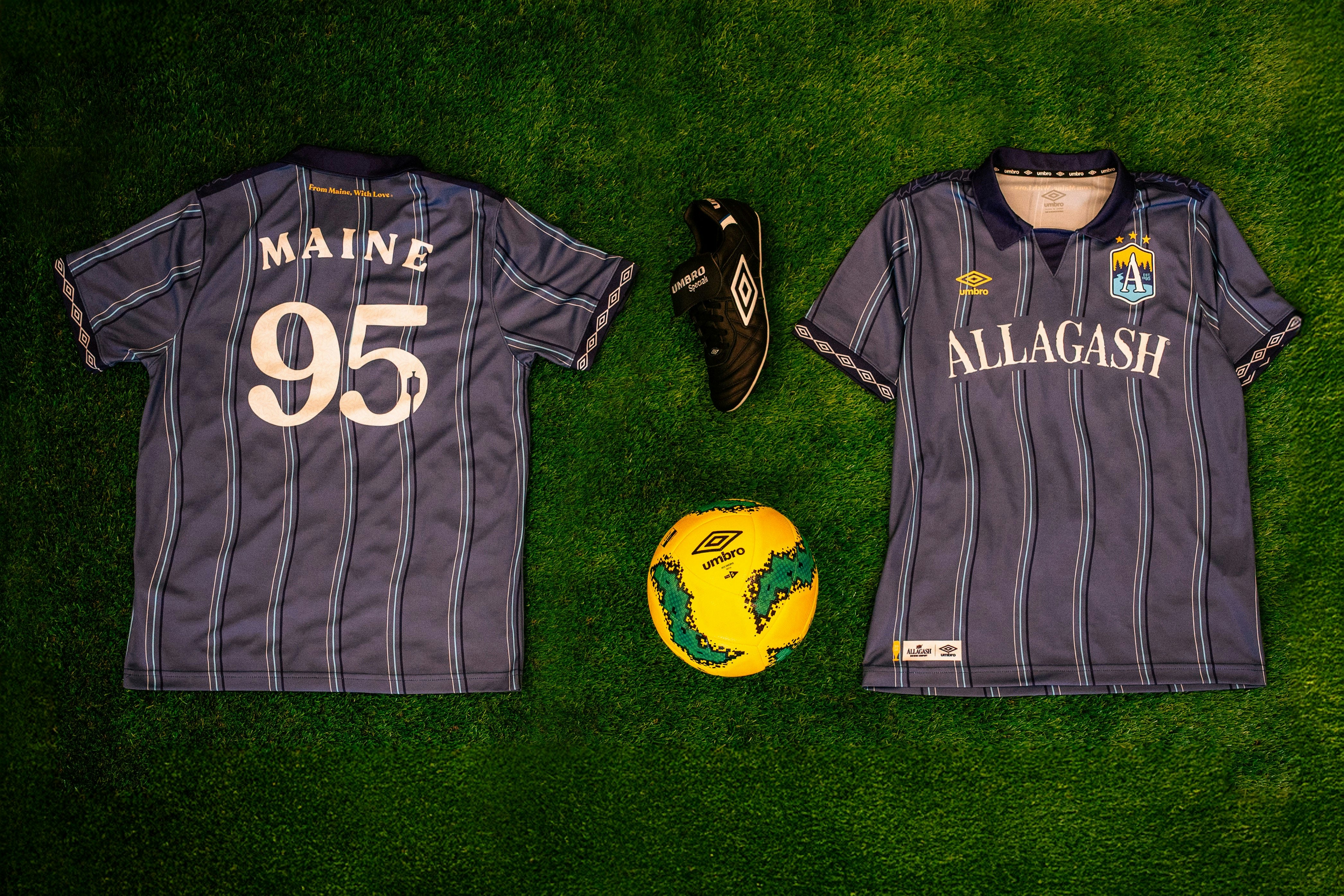 the back and front of a blue striped soccer jersey on astroturf. the jersey text reads Maine 1995 and Allagash