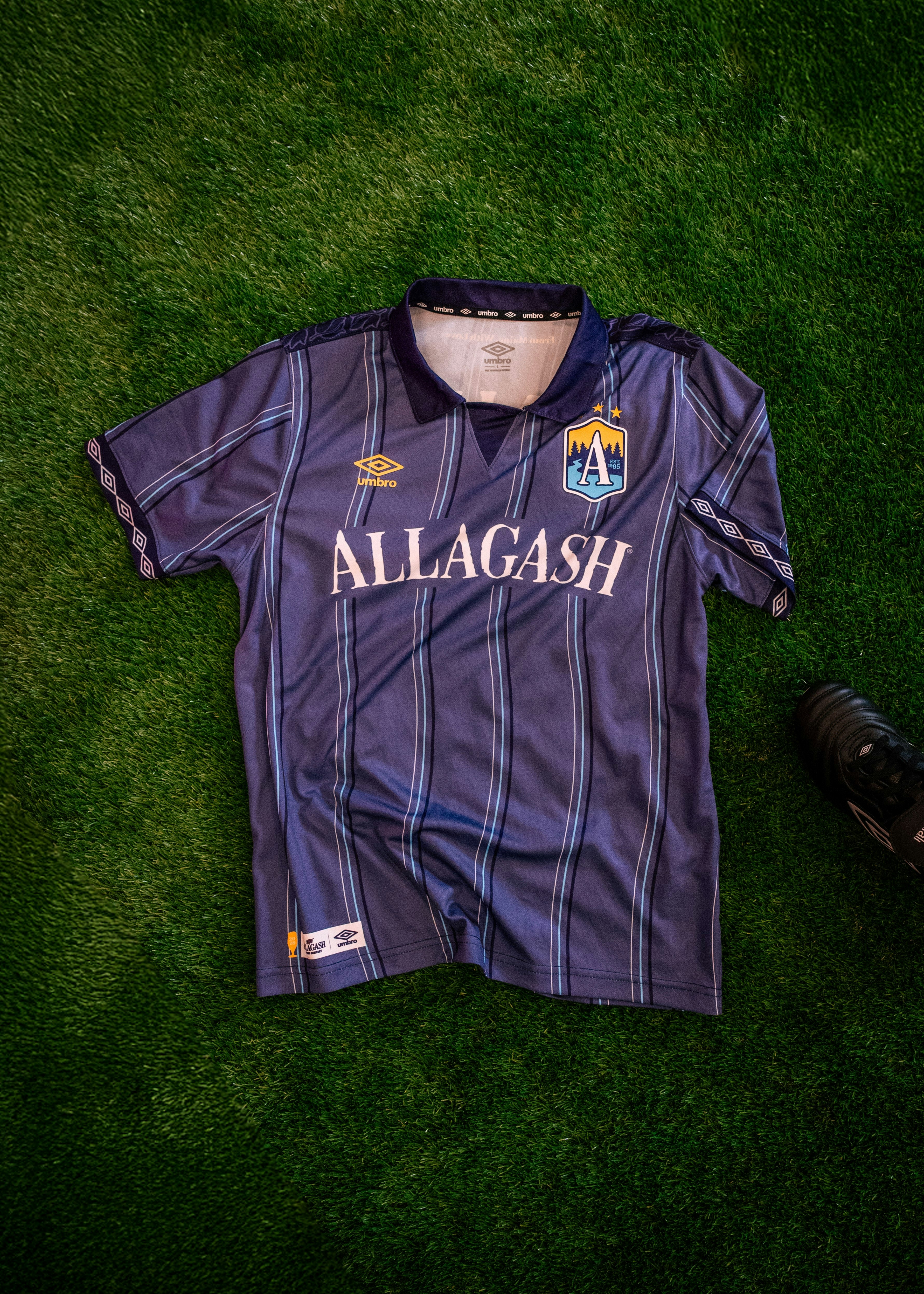 a blue striped soccer jersey on astroturf. the jersey text reads Allagash