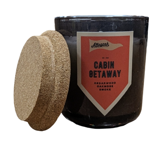 A glass jar candle with the cork lid removed