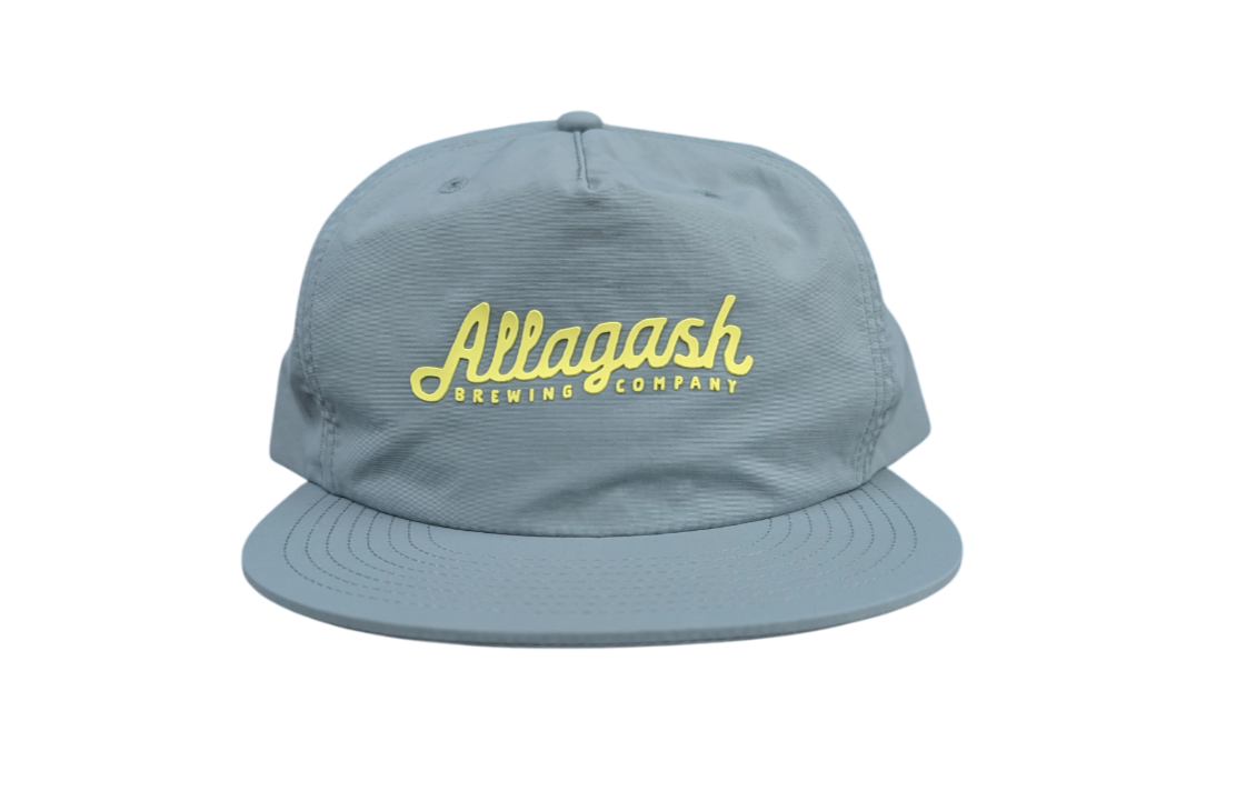 a blue hat with yellow text that reads Allagash Brewing Company