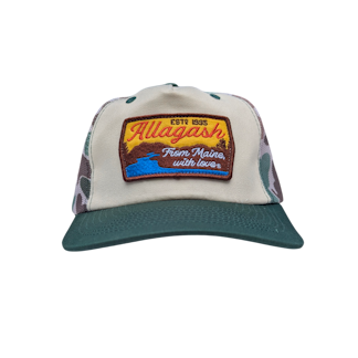 A trucker hat with a green bill, white front and a patch featuring a river scene