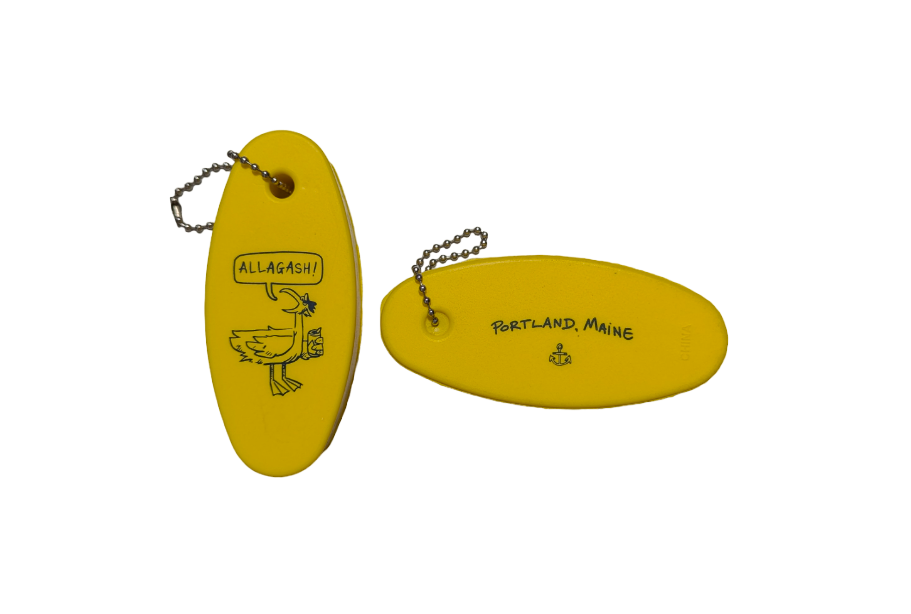 An oval shaped yellow keychain featuring a seagull with a word bubble that reads "Allagash". The opposite side features and anchor and the text "Portland Maine"