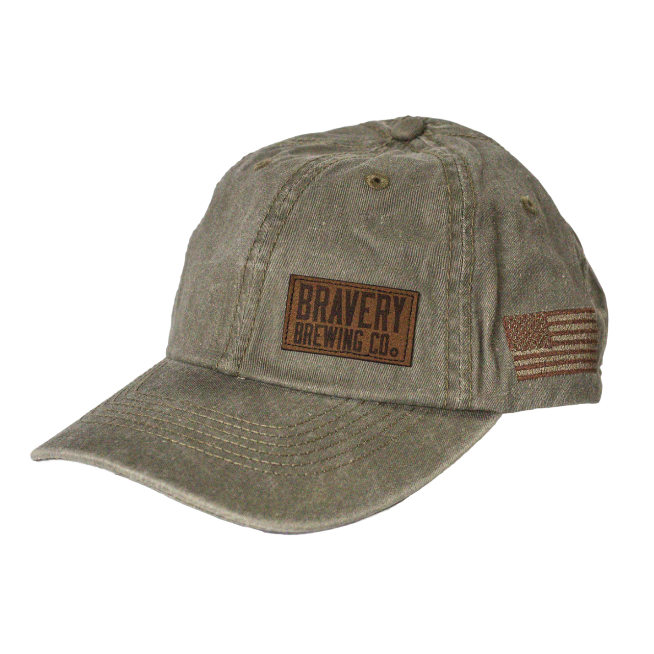 Front side photo of light green baseball cap on a white background. The hat is a worn weathered material with a brown embroidered flag on the side, and a leather suede patch sewn on to the front left panel of the hat.