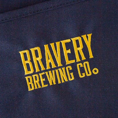Detail photo showing the Bravery logo text "Bravery Brewing Co." embroidered in yellow on the front of the cooler.