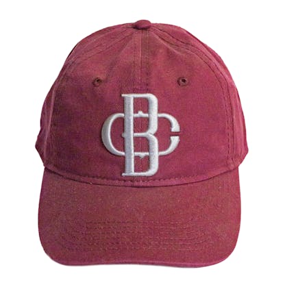 Front photo of maroon baseball cap on a white background. The fabric hat has a grey embroidered logo for the Bravura Collective centered on the front two panels.