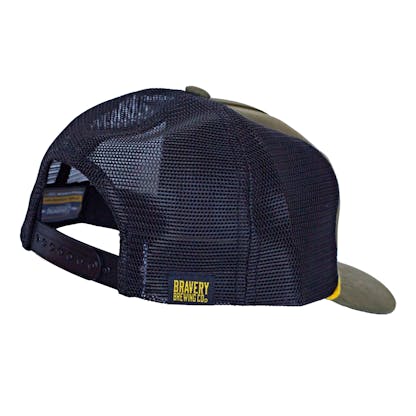 Back side photo of green trucker cap on a white background. The hat has green fabric for the front two panels and bill with black mesh for the back four panels. On the back right mesh panel there is a sewn on black and yellow tag that says "Bravery Brewing Co."