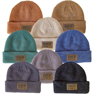 A photo of all of the knit beanie color options laying flat on a white background.