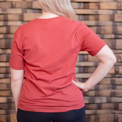Photo of a person wearing a shirt facing away from the camera. The shirt is red in color.