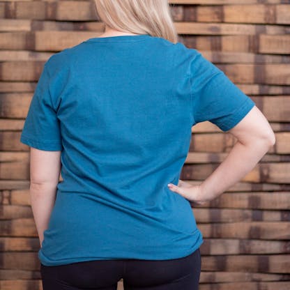 Photo of a person wearing a shirt facing away from the camera. The shirt is teal in color.