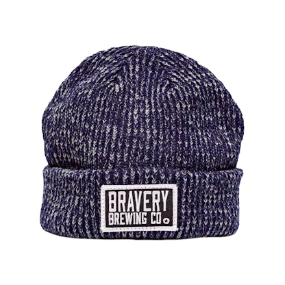 Photo of a knit beanie on a white background with a black and white embroidered patch sewn on the front. The hat is a blue and white marbled yarn and the patch has the text "Bravery Brewing Co." embroidered in white onto it.