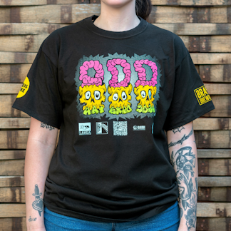 Photo of a person wearing a shirt facing the camera. The shirt is black in color with a colorful graphic print that reads "ODD ART EXPO 2024" across the chest.
